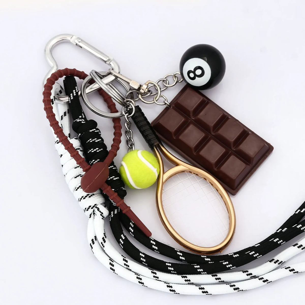 A keychain featuring a billiard ball, a chocolate bar, and a tennis racket on a white cord.