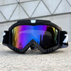 A pair of black windproof sports goggles with purple and blue mirrored lenses resting on a gray surface.