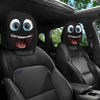Black car seat headrest covers featuring decorative, cartoonish eyes and smiles.