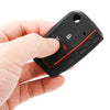 A hand holds a black silicone car key cover with a red accent, showing the key slot and a button.