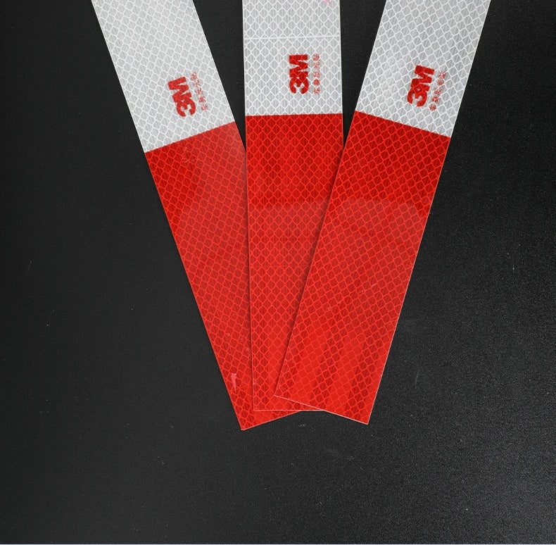 Three vertical strips of red high-visibility reflective decal material displayed against a black background.