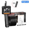 A black industrial endoscopic camera with a single lens and coiled cables is shown next to its packaging.