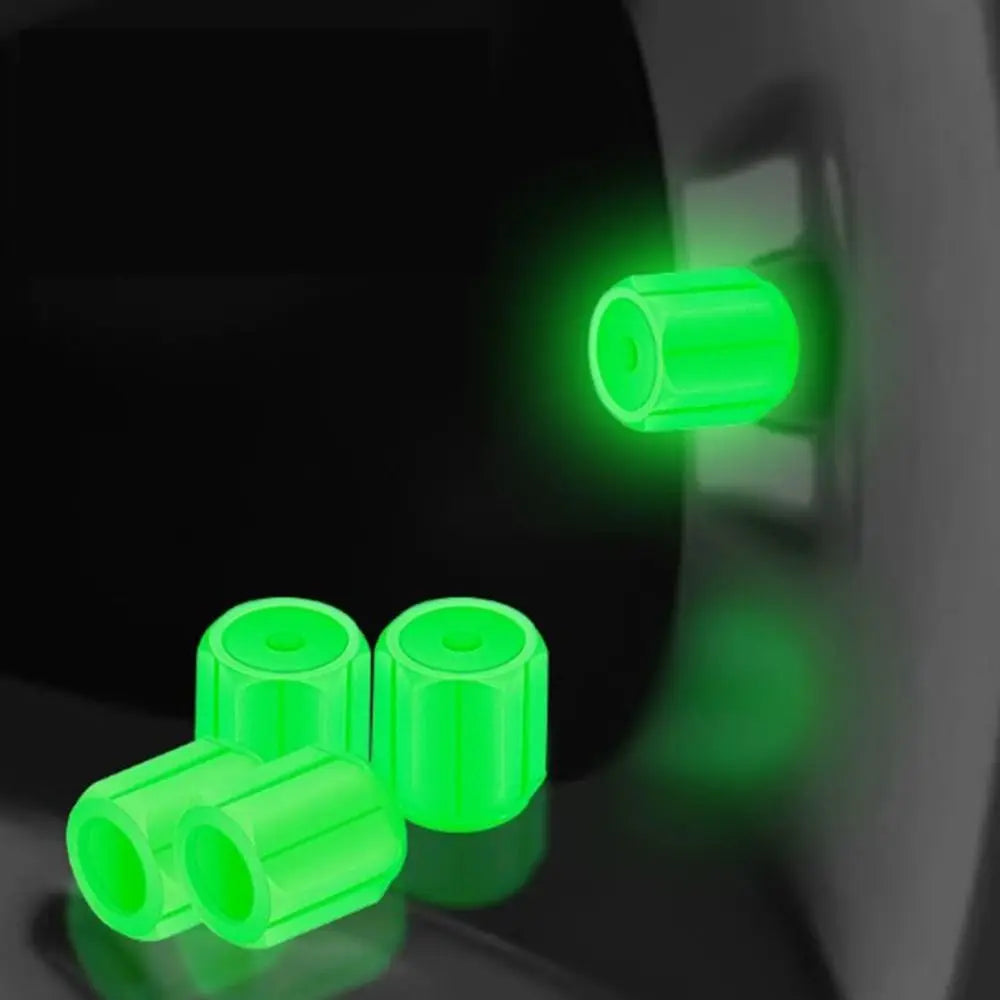 Green self-luminous tire valve caps are shown with a bright glow on a dark surface.