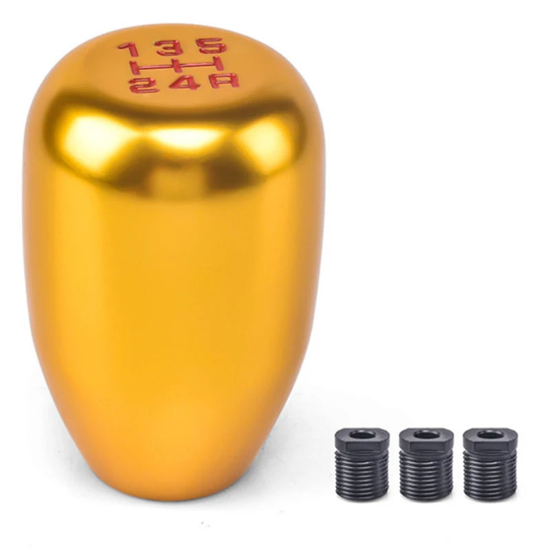 Glänzender goldener Universal-5-Gang-Metall-Schaltknauf mit Markierungen oben und mehreren separaten Metall-Schaltknöpfen dar