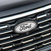 Close-up of a black car grille featuring a silver Ford emblem badge.