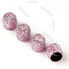 A set of pink crystal diamond finish tire valve caps arranged diagonally on a white background.