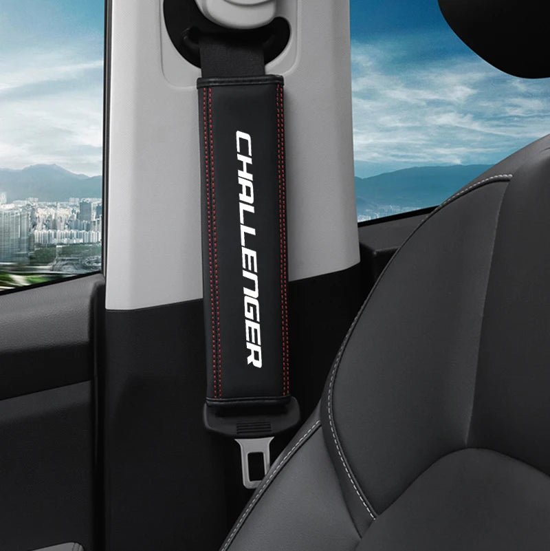 A black and red Challenger car seat belt shoulder strap pad is shown mounted on a vehicle interior panel.