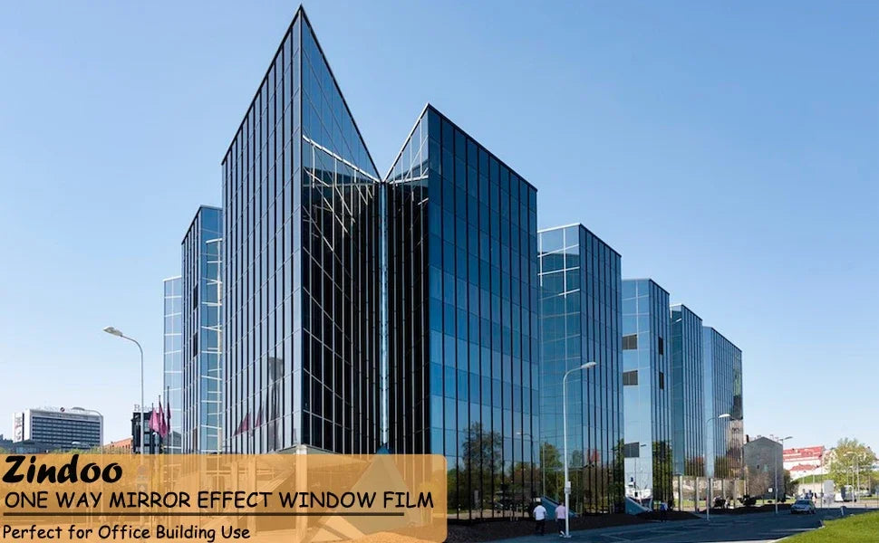 Modern glass office building facade showcasing a silver reflective privacy window film installation.