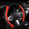 A black steering wheel with an orange accent rim and silver controls inside a car interior.