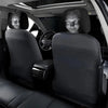 A set of two black Halloween horror face headrest covers installed in a car seat.