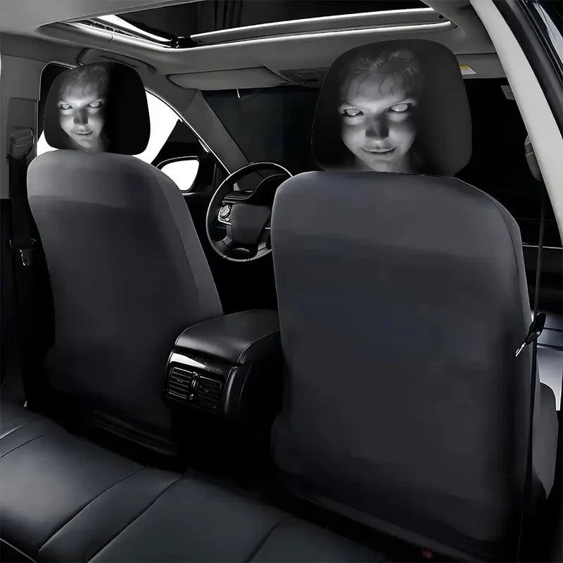 A set of two black Halloween horror face headrest covers installed in a car seat.