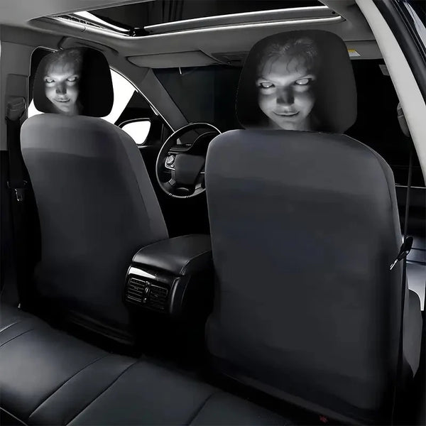 A set of two black Halloween horror face headrest covers installed in a car seat.