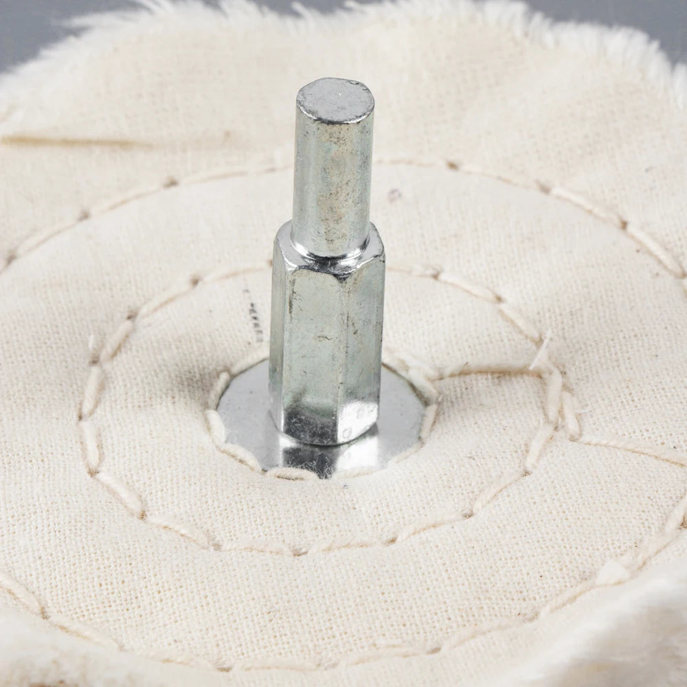 A silver 1/4 shank polishing wheel used for jewelry and metalwork is shown against a light beige fabric background.
