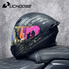 Un casque de moto modulaire noir avec une visière colorée est exposé sur un siège de moto.