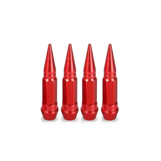 A set of four red aluminum tire valve stem caps standing upright.