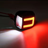 A close-up of an LED license plate light illuminating a red surface.