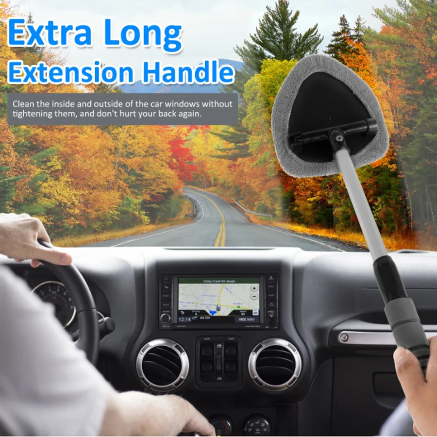 A hand holds an extra long extension handle for a car window cleaning brush, demonstrating its use.