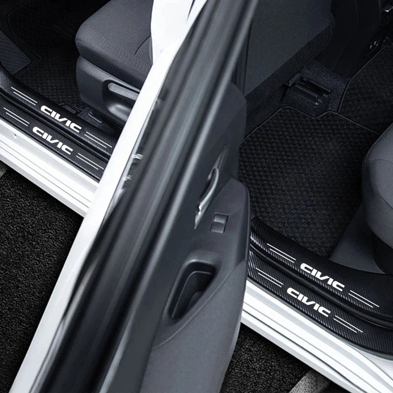 Close-up view of carbon fiber door sill protectors installed on a vehicle interior.
