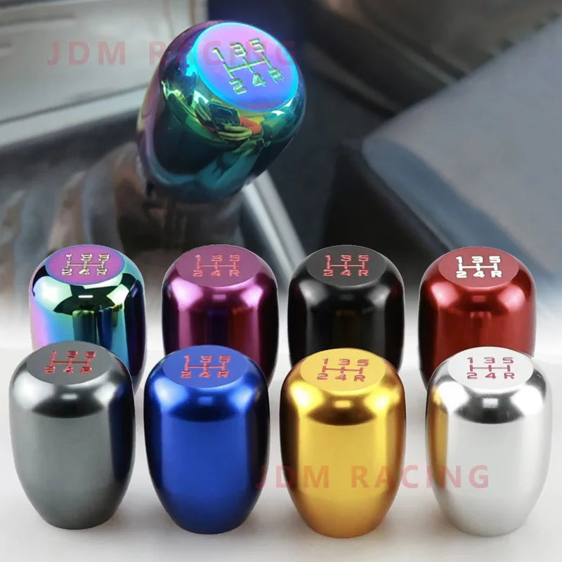A collection of universal aluminum gear shift knobs in various colors including purple, pink, black, blue, gold, and silver.