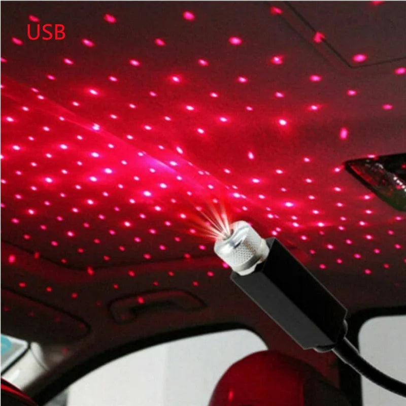 A portable LED star projector night light shining red dots onto a car's interior ceiling.