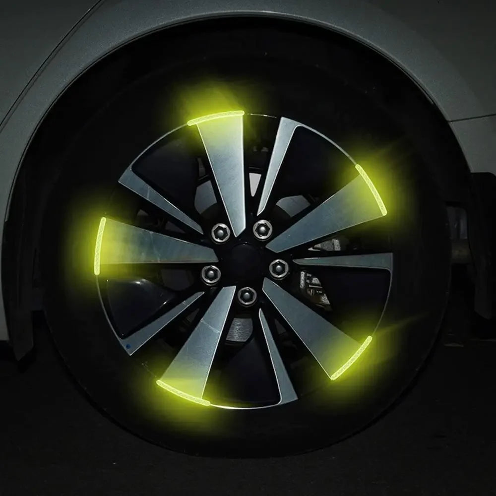 Gros plan d'une roue noire avec des accents LED jaunes vifs et des autocollants réfléchissants.
