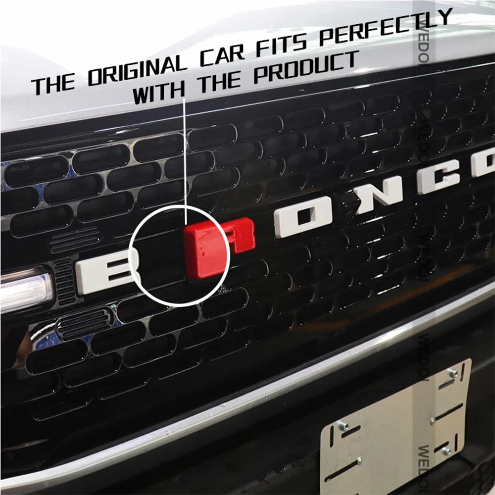 Gros plan d'un badge lettre rouge ajustant parfaitement la grille d'un Ford Bronco.