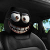 Diseño de cara de dibujos animados negra en funda para reposacabezas de coche, con boca ancha sonriente y ojos grandes.