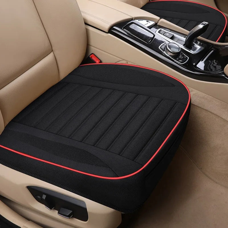 Black breathable car seat covers installed in a beige car interior with leather upholstery and controls visible.
