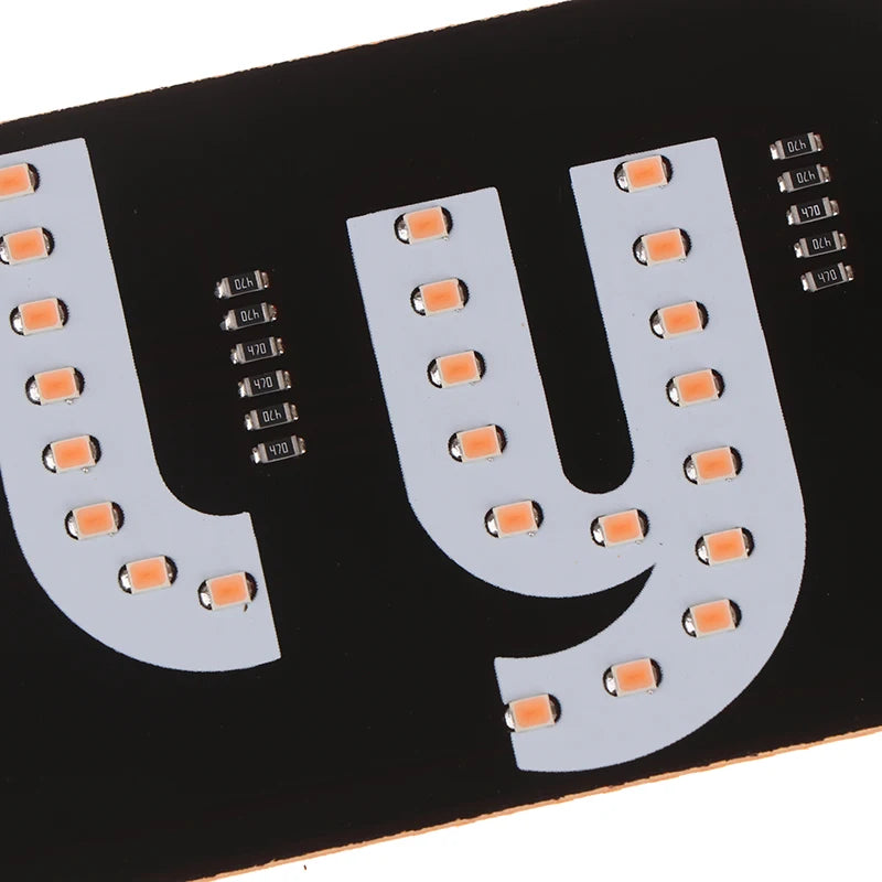 Placa de circuito negro con una gran letra U en blanco, que presenta múltiples luces indicadoras de taxi LED.