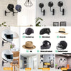 Divers supports et crochets pour casques de moto de différentes tailles et styles, exposés sur un mur de briques blanches.