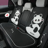 A set of black and white cartoon panda themed car seat cushions installed in a vehicle interior.