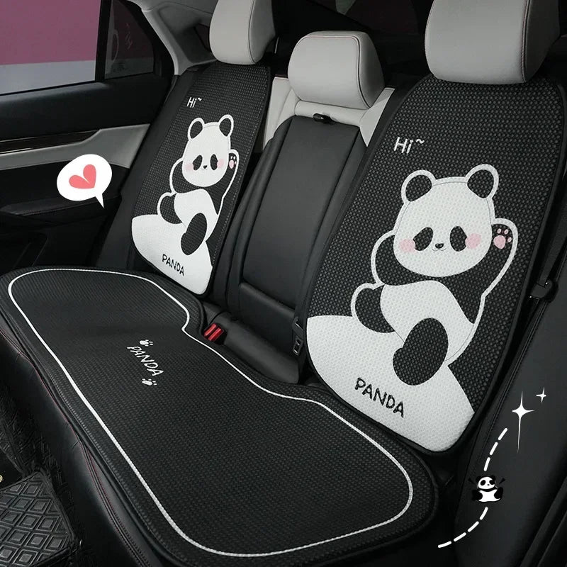 A set of black and white cartoon panda themed car seat cushions installed in a vehicle interior.