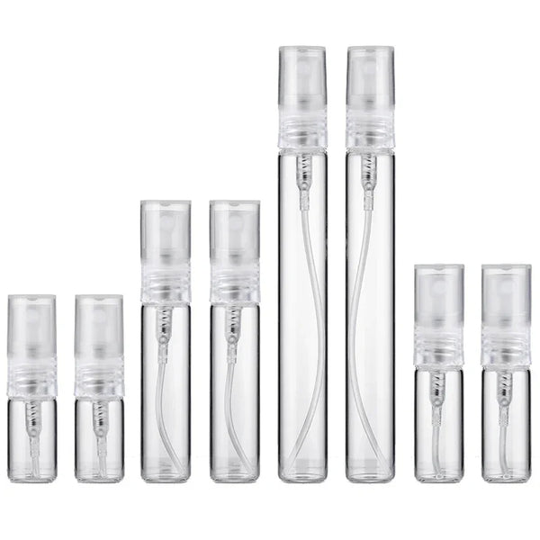 Un set de seis frascos de perfume de vidrio transparente con tapas plateadas y goteros de vidrio.