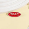 A red oval enamel lapel pin featuring the Peterbilt logo on a light yellow background.