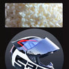 Close-up of white ABS mixture material used in helmet construction next to a black and red racing-style helmet.