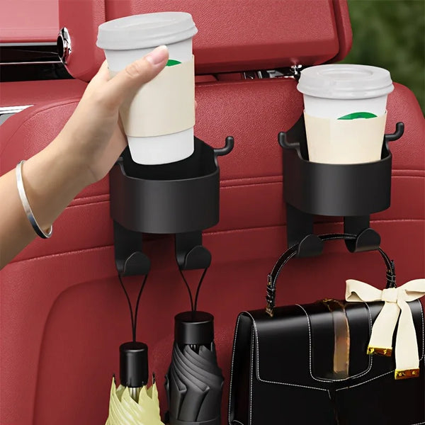 Una mano coloca una taza blanca en un gancho de soporte para vasos del asiento de un coche negro interior rojo.