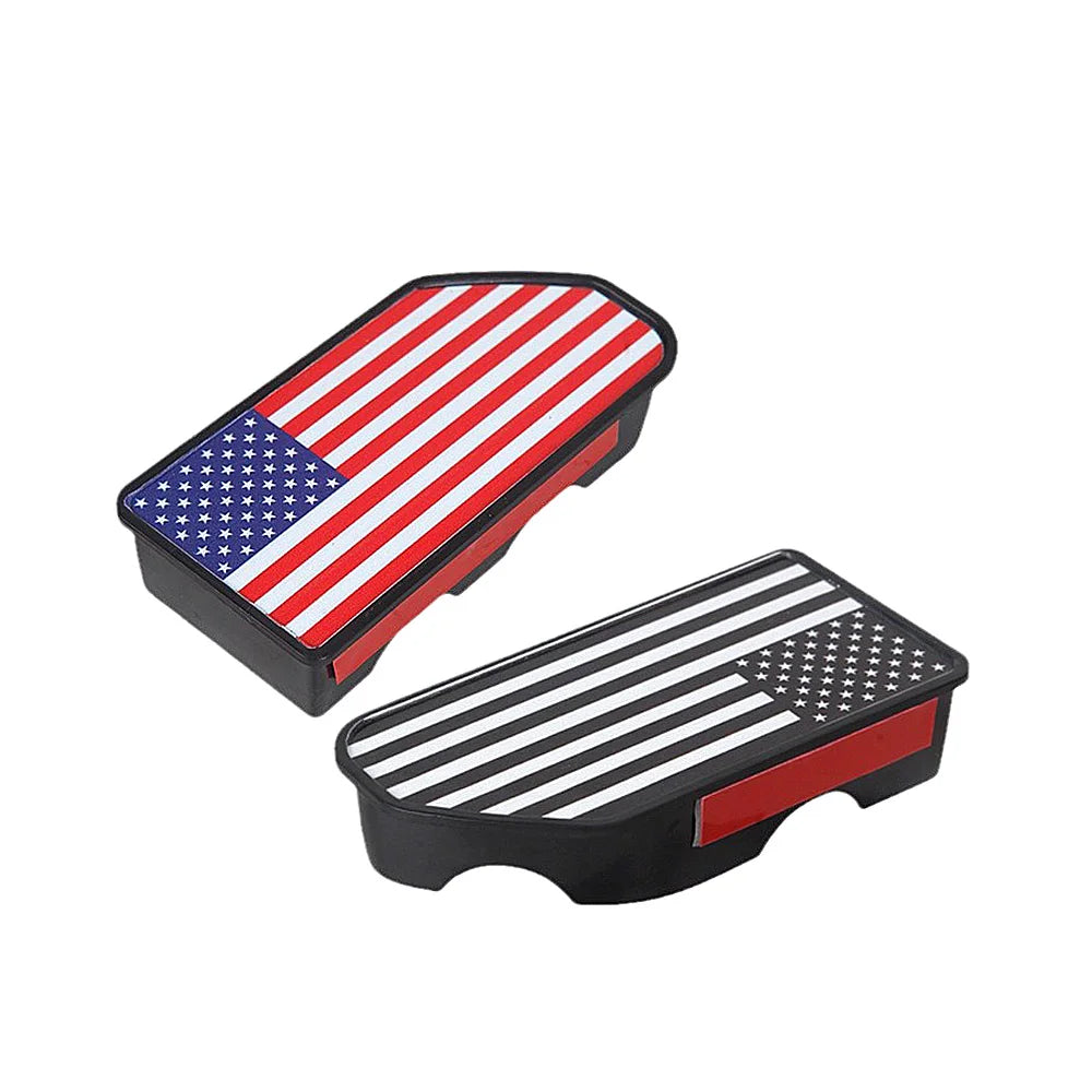 A black truck bed rail hole plug featuring the American flag design with red and white stripes and blue stars.