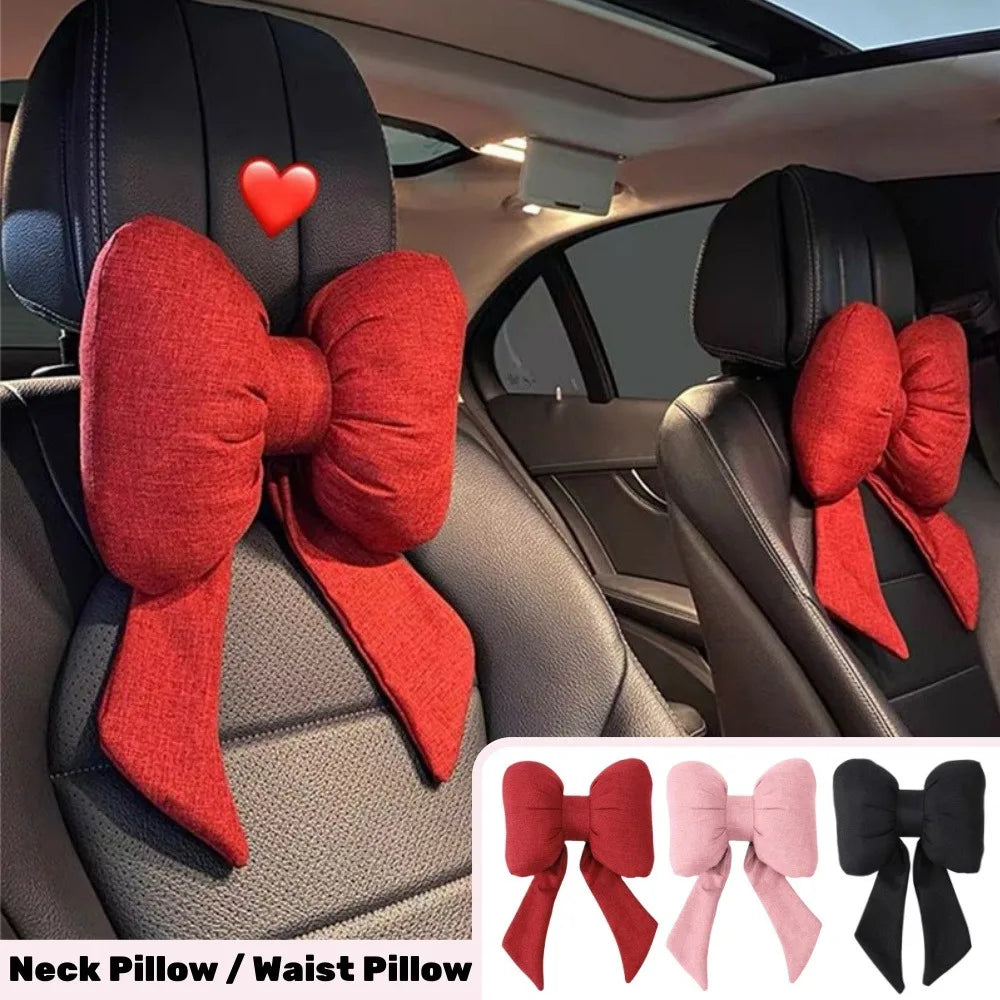 A set of pink and red bow knot neck pillows for car use shown in a vehicle interior.