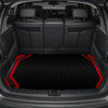 Interior view of a car with black leather seats and a textured red and black trunk mat.