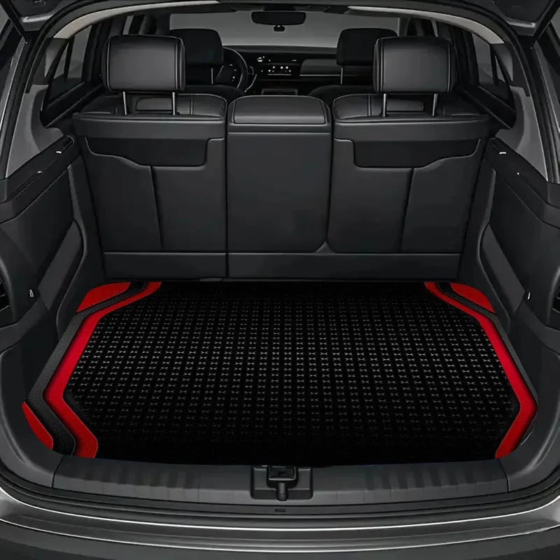 Interior view of a car with black leather seats and a textured red and black trunk mat.