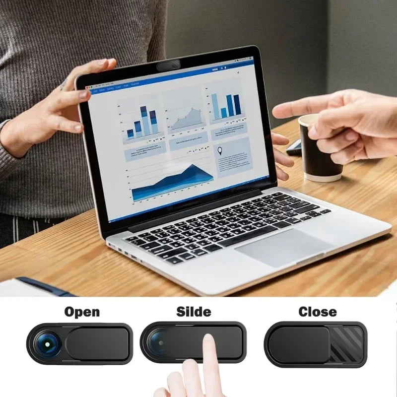 A hand is demonstrating a sliding privacy camera cover for a laptop, showing open and closed positions.