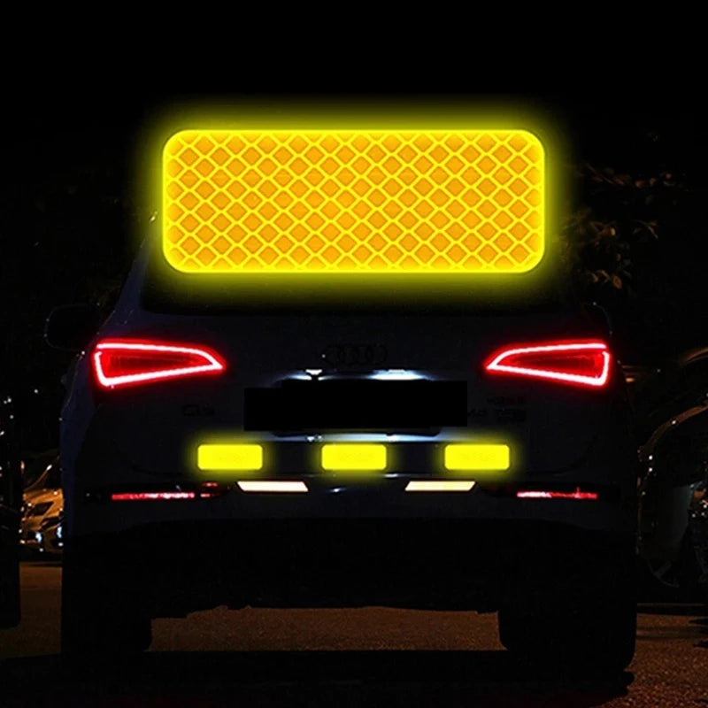 Rear view of a vehicle with bright yellow reflective safety strips illuminated.