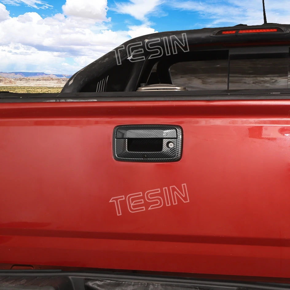 Close-up of a red truck tailgate with a black TESIN trim handle cover.