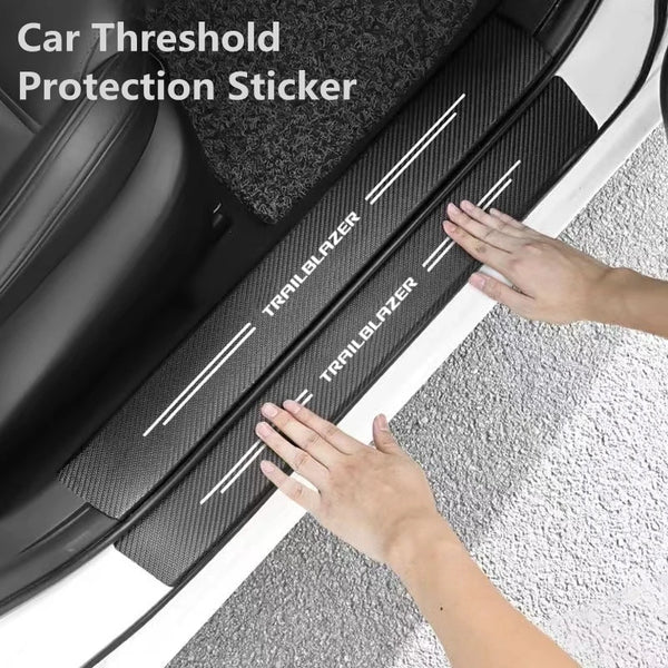 Una mano aplica una pegatina de protección de fibra de carbono en el revestimiento interior de una puerta o maletero de coche