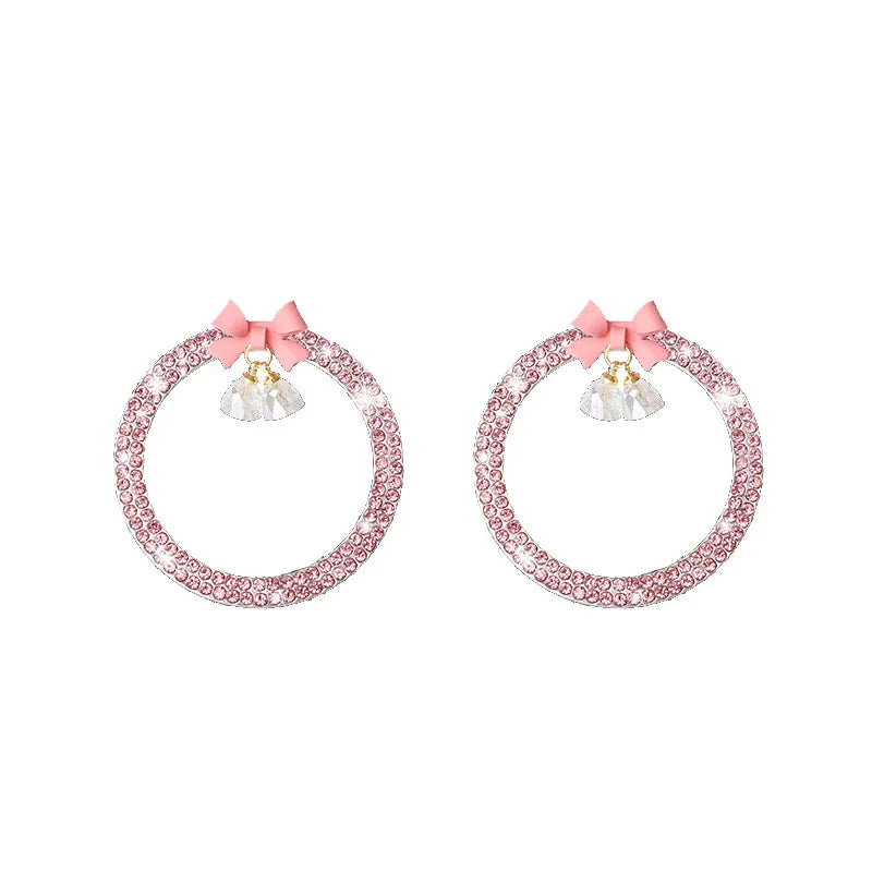 A pair of decorative rhinestone bow bell car start switch button trim pieces.