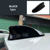 Black shark fin roof antenna cover installed on a white car.