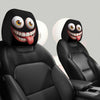 A set of two funny cartoon car headrest covers featuring big-eyed, tongue-out designs on black upholstery.