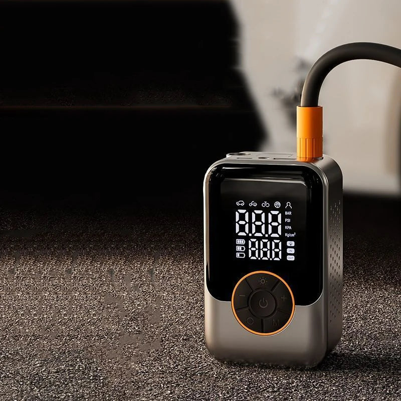 A silver wireless portable tire inflator with an orange nozzle and a digital display is shown on a dark surface.