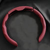 A close-up view of a red breathable perforated leather steering wheel cover.