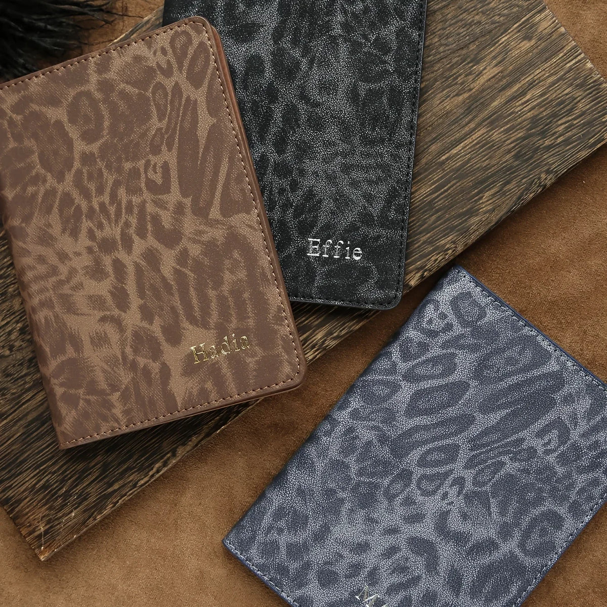 A stack of personalized leopard print passport holders in brown and gray tones.